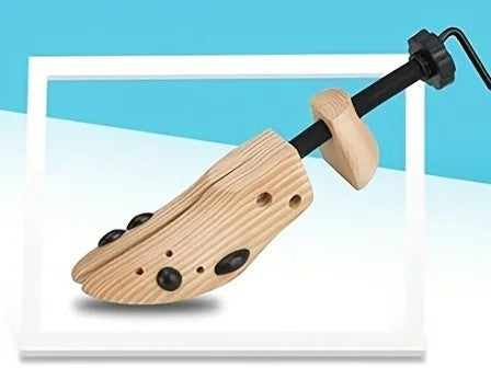 Allarga scarpe in legno chiaro con vite nera e tappi neri nei fori della punta
