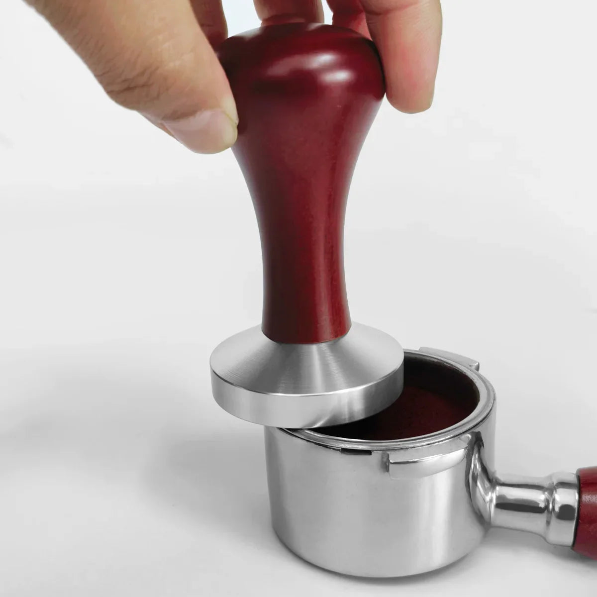 Pressino caffè con manico in legno premuto in un portafiltro