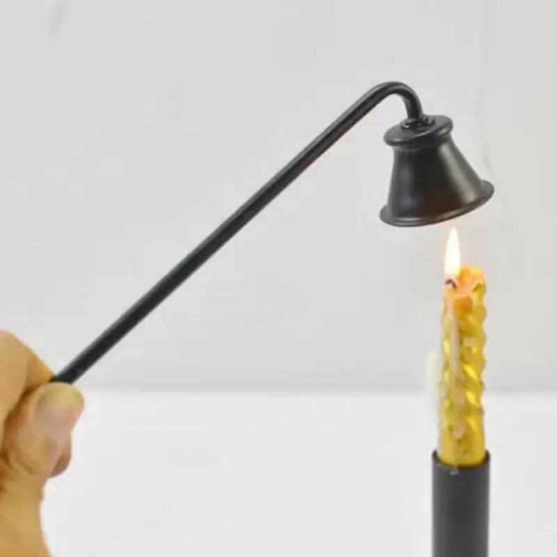 Spegnicandela nero con la campana sopra la fiamma di una candela