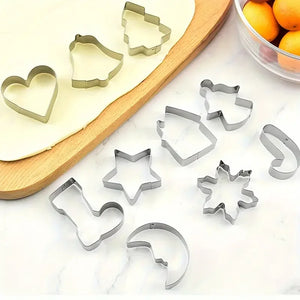 Formine per biscotti di Natale in acciaio inox – tutti i 10 soggetti su un piano accanto alla pasta stesa