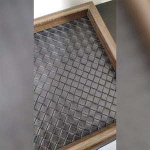 Foto di un cliente: il fondo nero in similpelle intrecciata e la cornice color legno dello svuotatasche