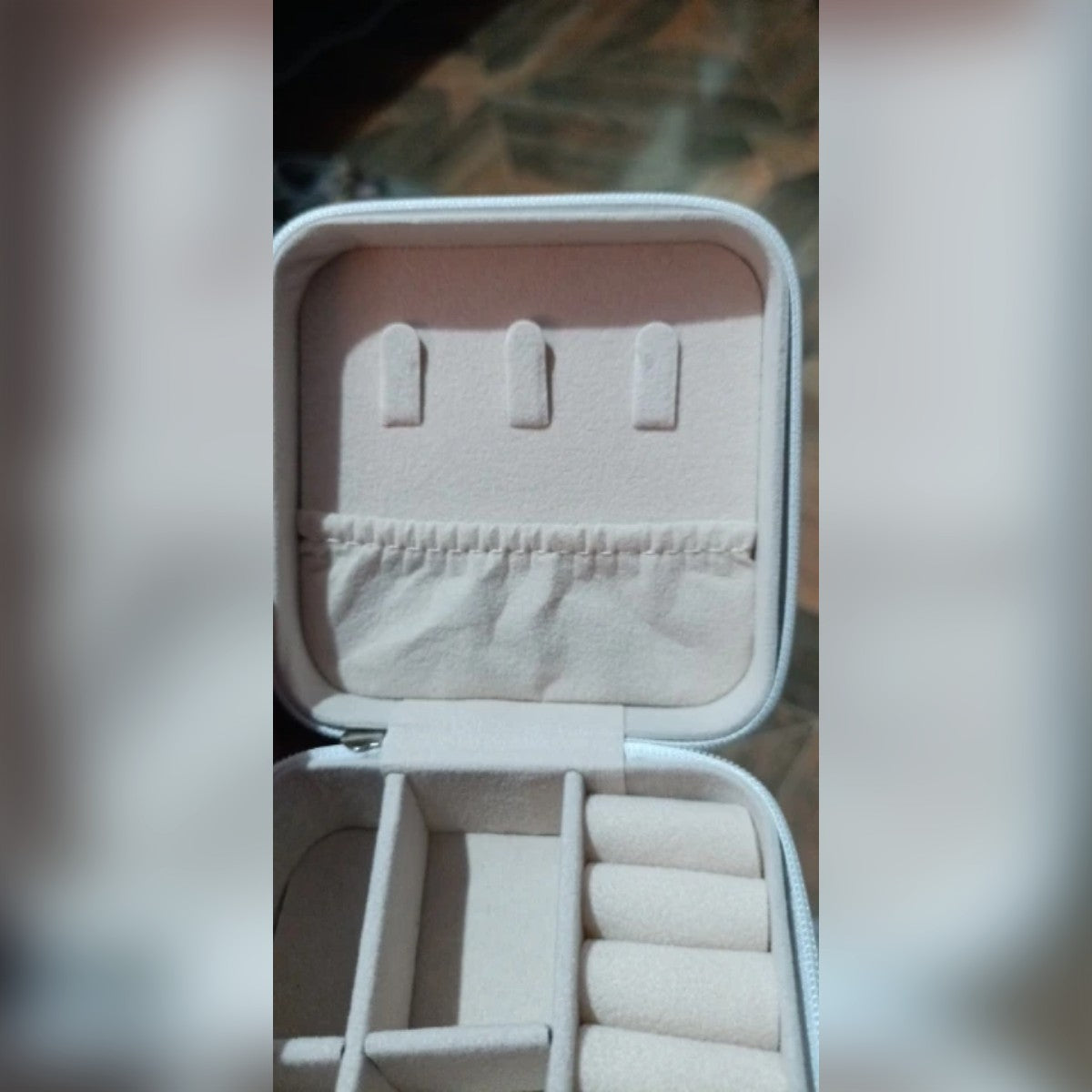 Foto di un acquirente: il portagioie bianco aperto e vuoto, con rulli e scomparti
