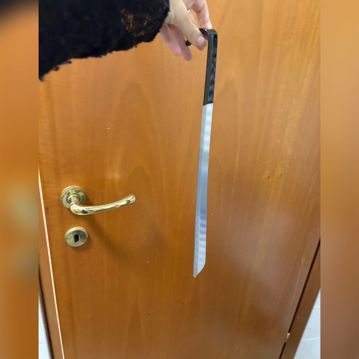 Foto di un acquirente: il calzascarpe tenuto per il gancio davanti a una porta