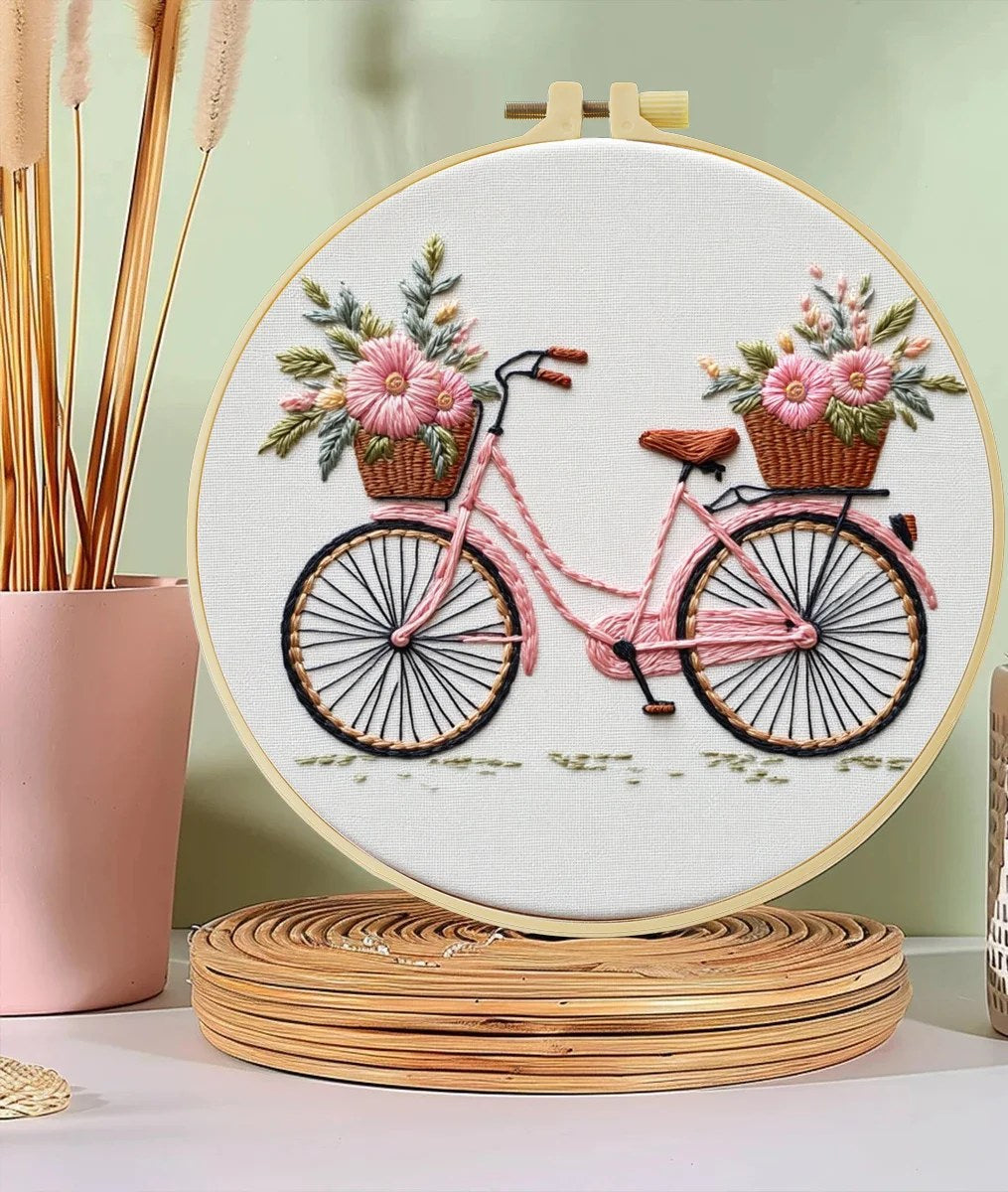 Kit ricamo con bicicletta e cesti di fiori – il ricamo finito nel telaio su una mensola, foto del fornitore