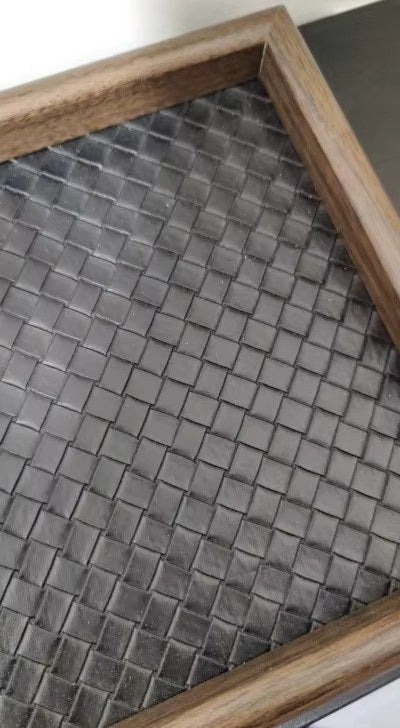 Svuotatasche nero con cornice effetto legno su un comodino