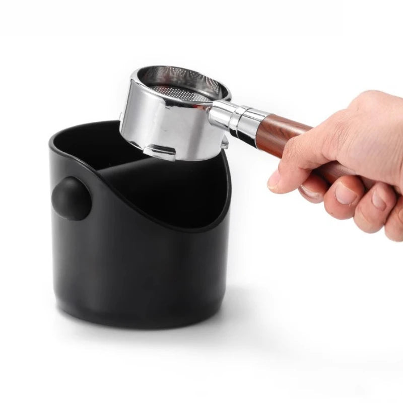 Battifondi caffè mini nero: un portafiltro tenuto sopra il contenitore