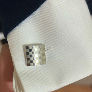 Foto di un cliente: gemello quadrato a scacchi sul polsino di una camicia bianca