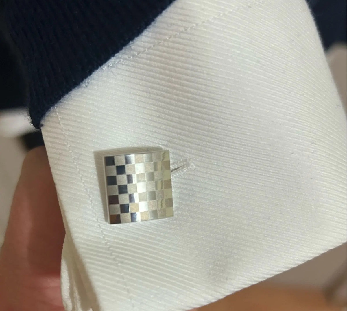 Foto di un cliente: gemello quadrato a scacchi sul polsino di una camicia bianca