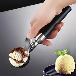 Porzionatore per gelato con leva e manico nero, accanto a una pallina di gelato alla vaniglia e cioccolato