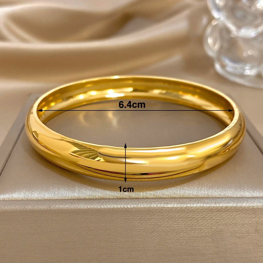 Bracciale rigido color oro con il diametro interno di 6,4 cm e la larghezza di 1 cm indicati