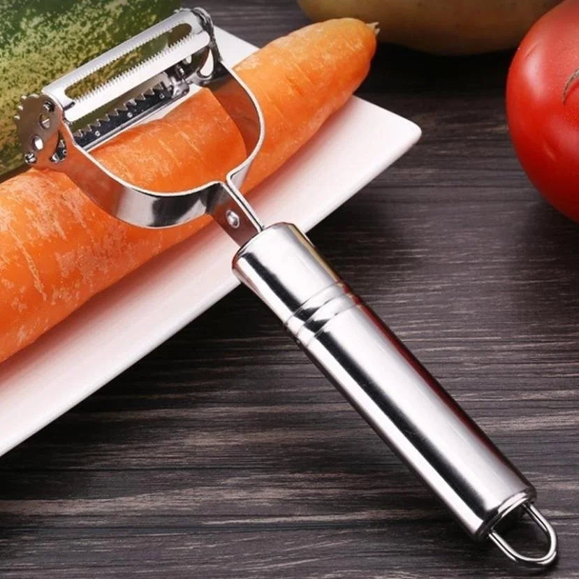 Pelapatate julienne con manico tubolare in acciaio e anello, appoggiato su una carota