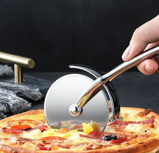 Il tagliapizza scorre su una pizza fatta in casa