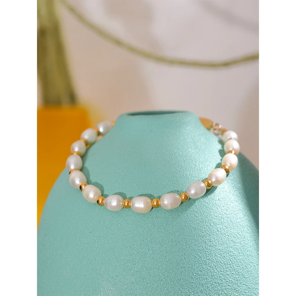 Bracciale di perle appoggiato su un vaso turchese