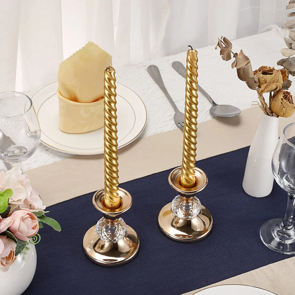 I candelieri con candele lunghe su una tavola apparecchiata con runner blu
