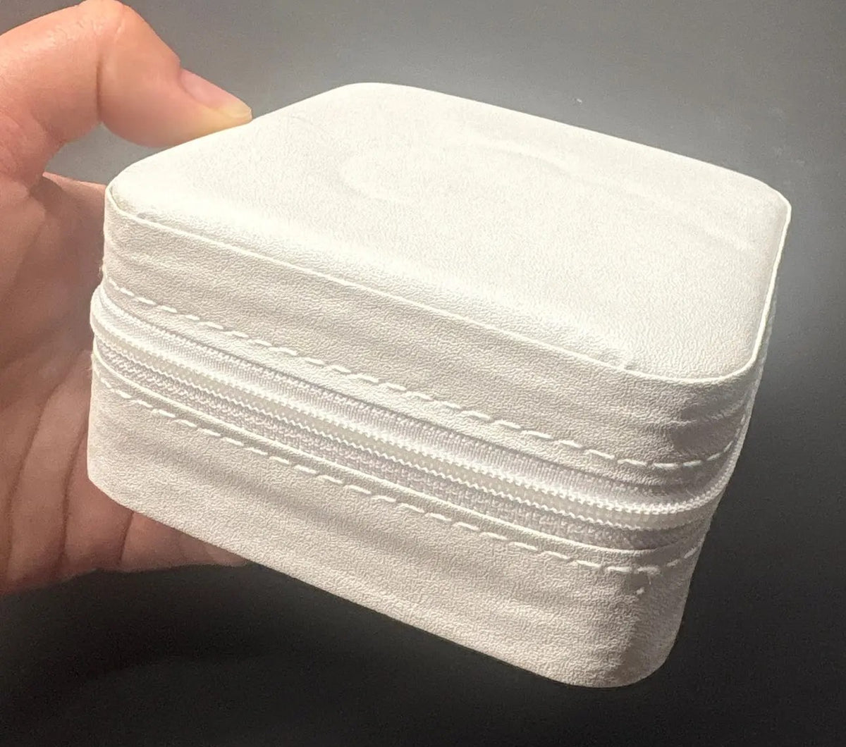 Foto di un acquirente: il portagioie bianco chiuso con la cerniera, tenuto in una mano