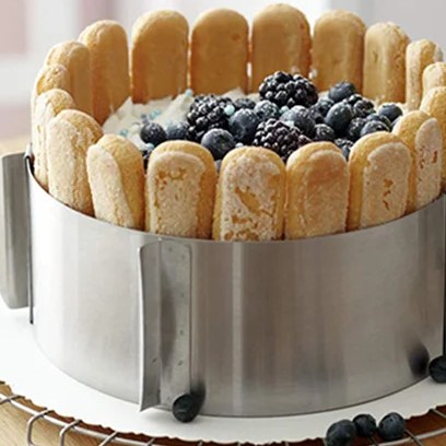 Anello per torte intorno a una charlotte con savoiardi lungo il bordo e mirtilli e more sopra