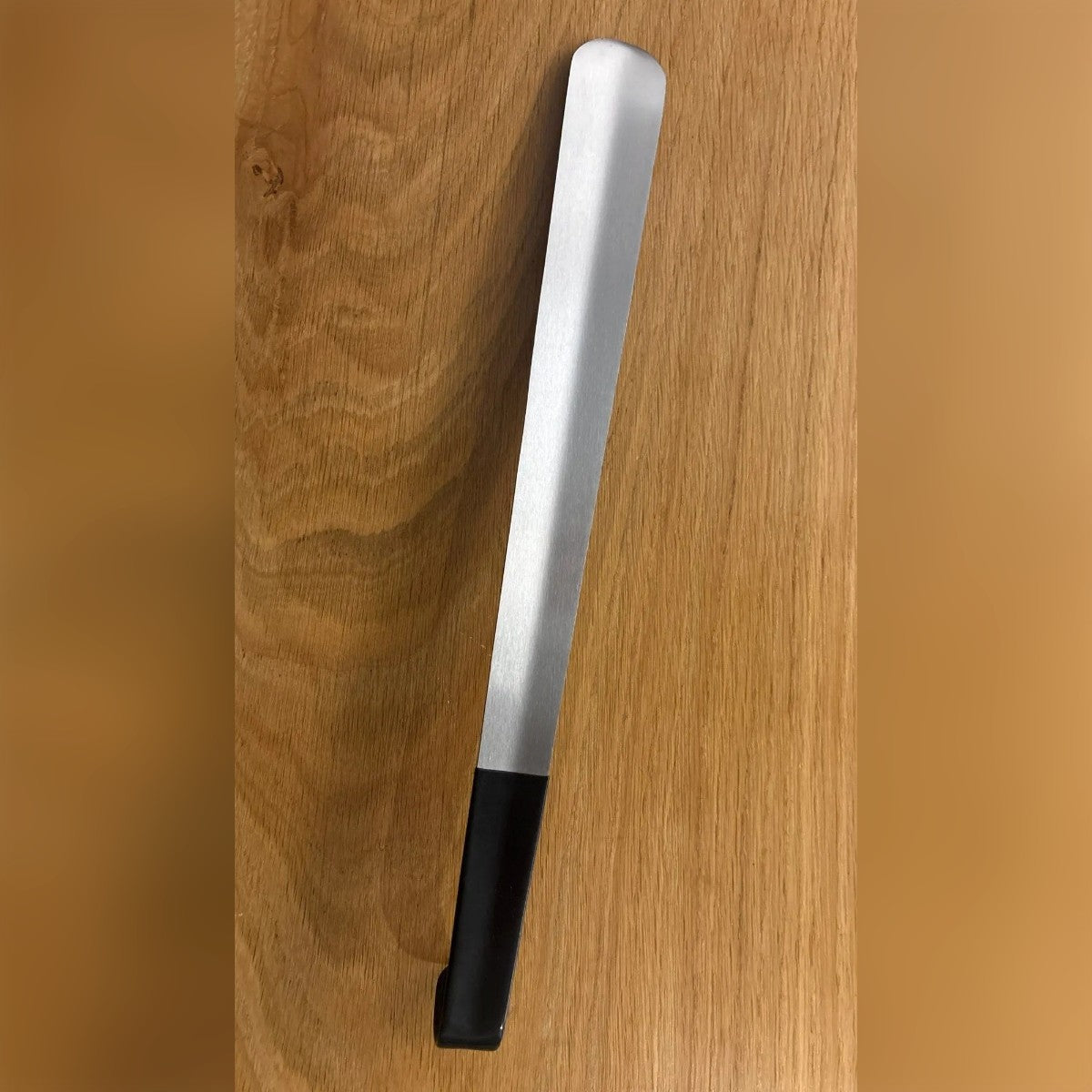 Foto di un acquirente: il calzascarpe ricevuto, appoggiato su un tavolo di legno