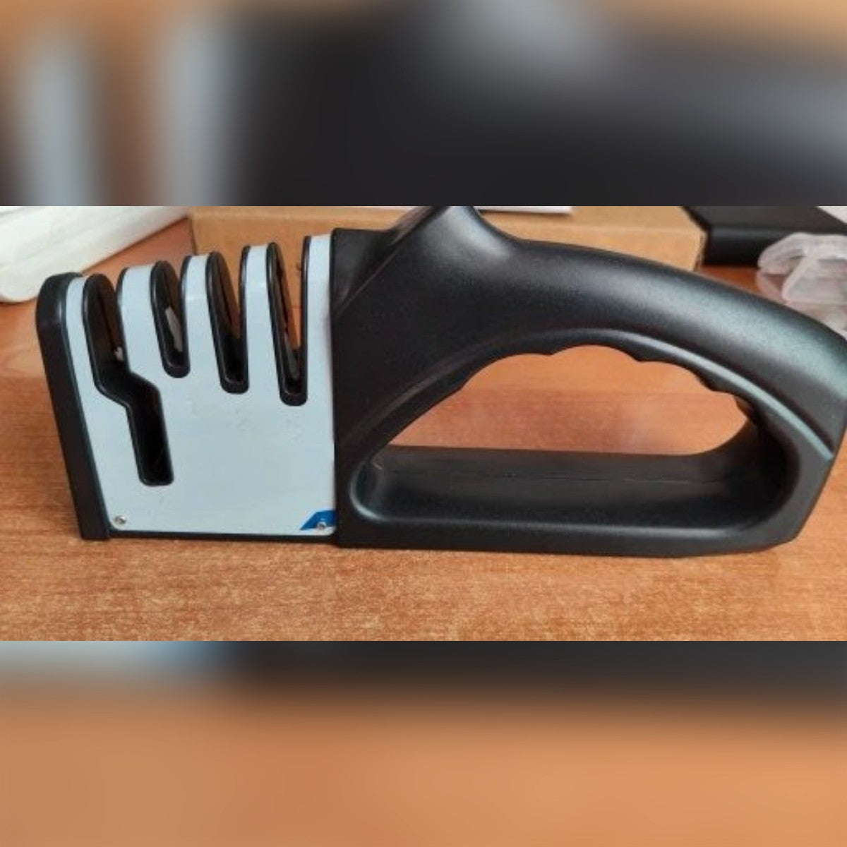 Foto di un acquirente: l'affilacoltelli ricevuto, appoggiato su un tavolo di legno