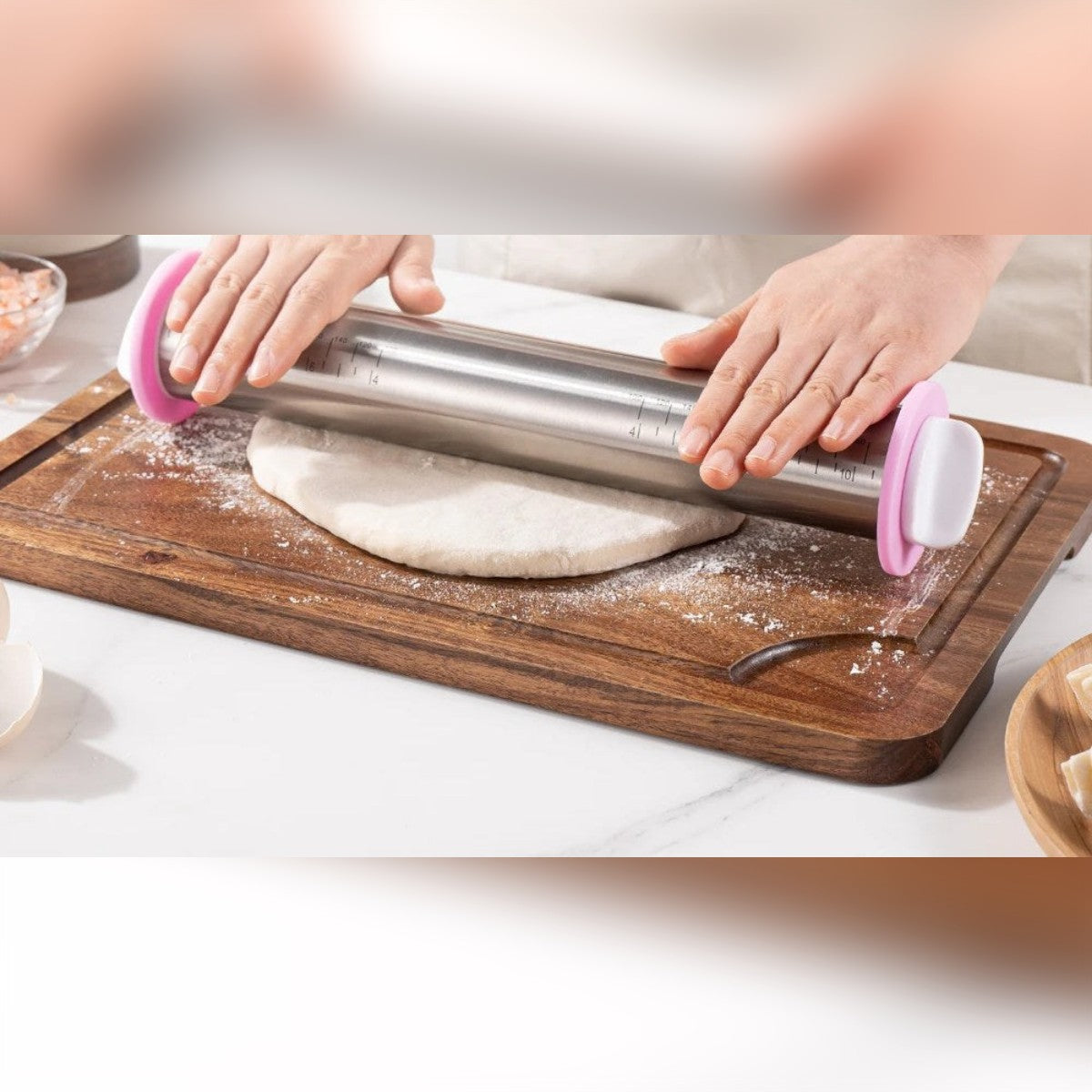 Mattarello con spessori in acciaio inox che stende la pasta su un tagliere di legno