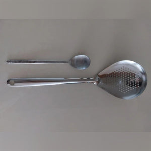 Foto di un acquirente: la schiumarola in acciaio inox accanto a un normale cucchiaio