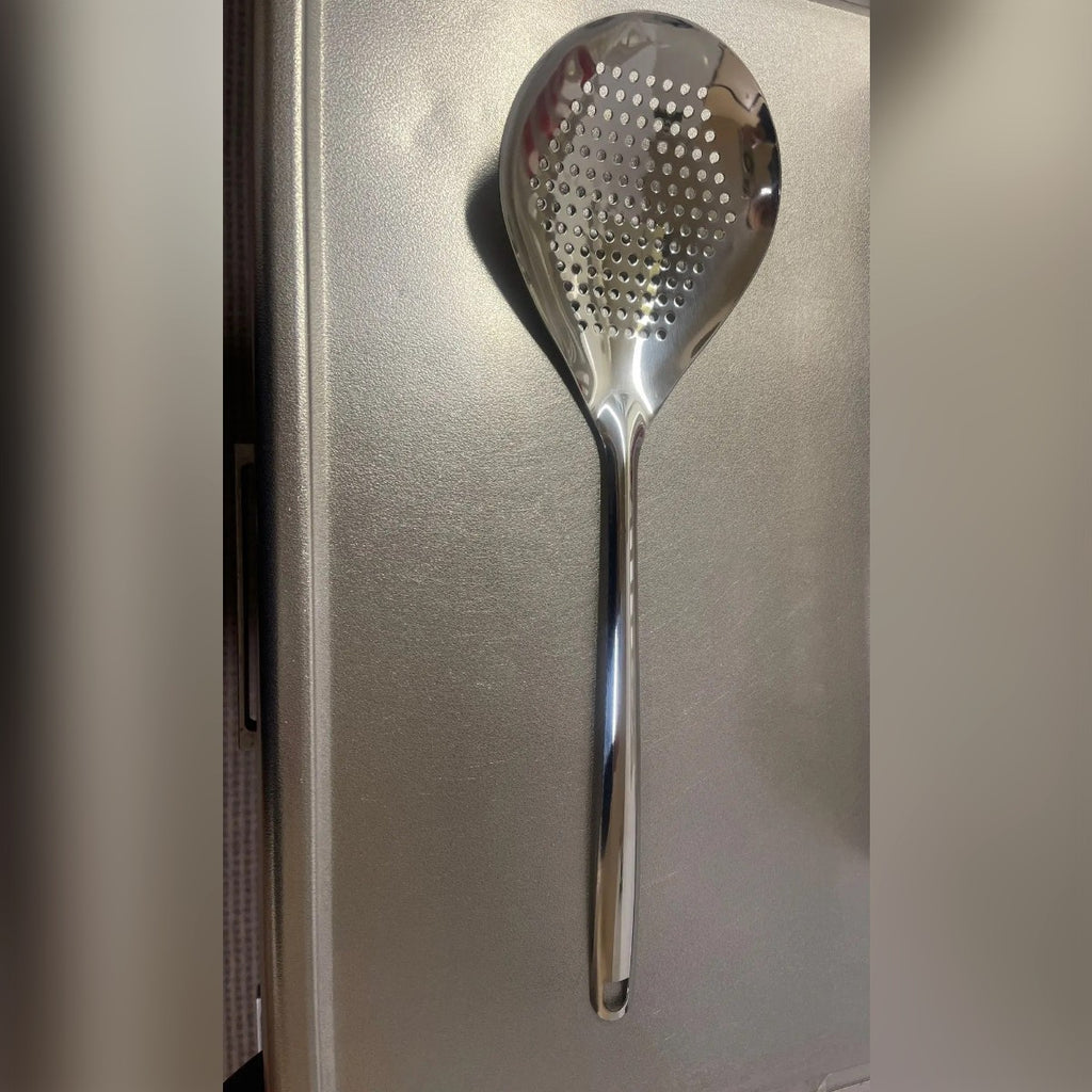 Foto di un acquirente: la schiumarola su un piano di lavoro, con coppa larga a fori tondi e manico lungo