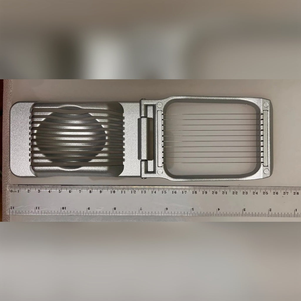 Foto di un acquirente: il taglia uova aperto accanto a un righello, circa 25,5 cm