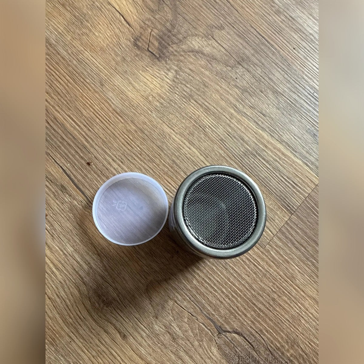 Foto di un acquirente: lo spargi zucchero con la rete in alto e il tappo di plastica accanto