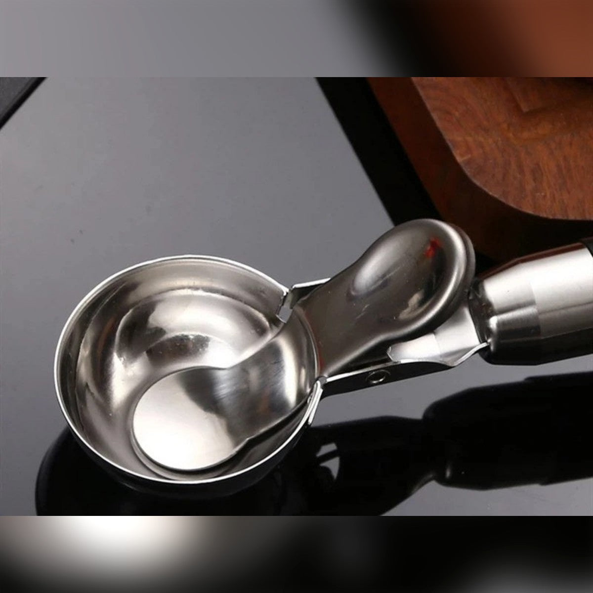 La coppa del porzionatore in acciaio inox con il raschietto all'interno e la leva sul lato