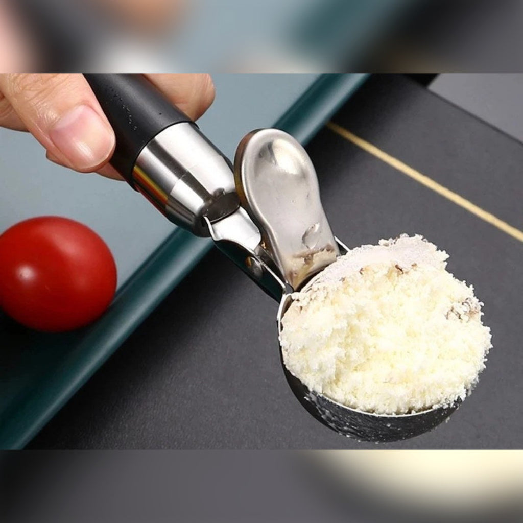 Porzionatore per gelato tenuto in mano con la coppa piena