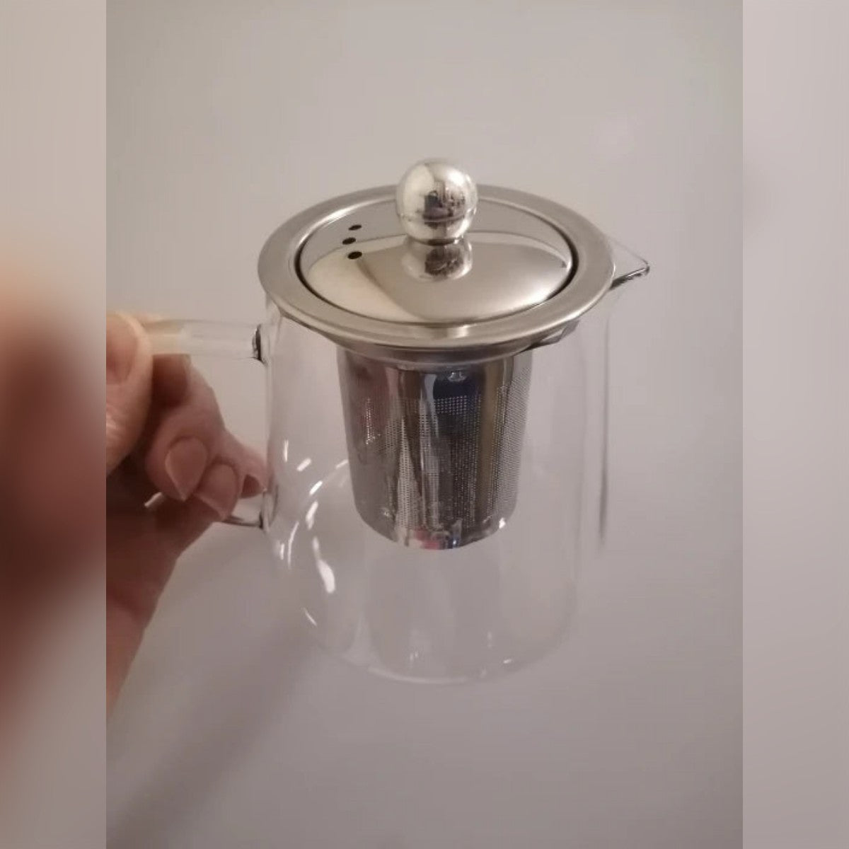 Foto di un cliente: la piccola teiera in vetro tenuta in mano, con coperchio e infusore