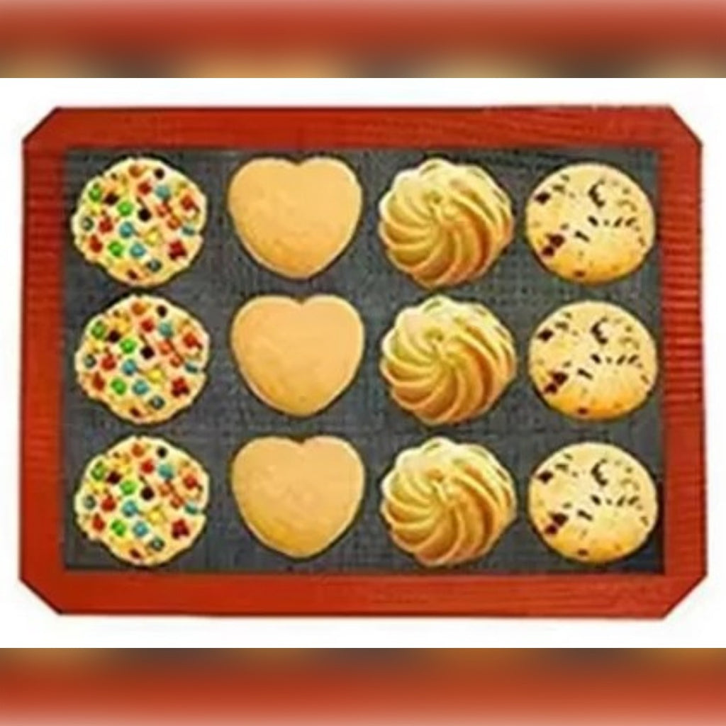 Biscotti di diverse forme sul tappetino forato con il bordo rosso