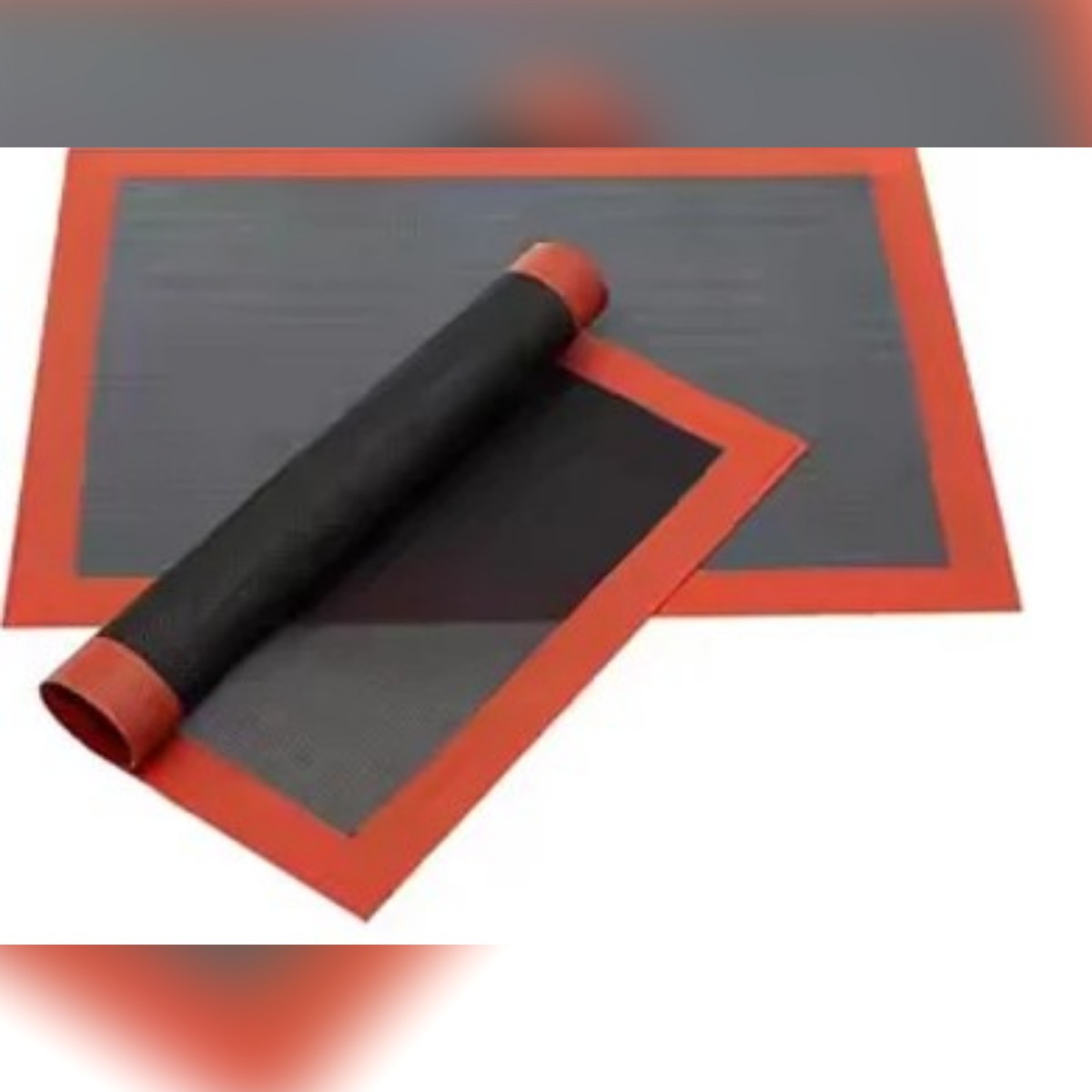 Il tappetino in silicone forato arrotolato accanto a un tappetino steso