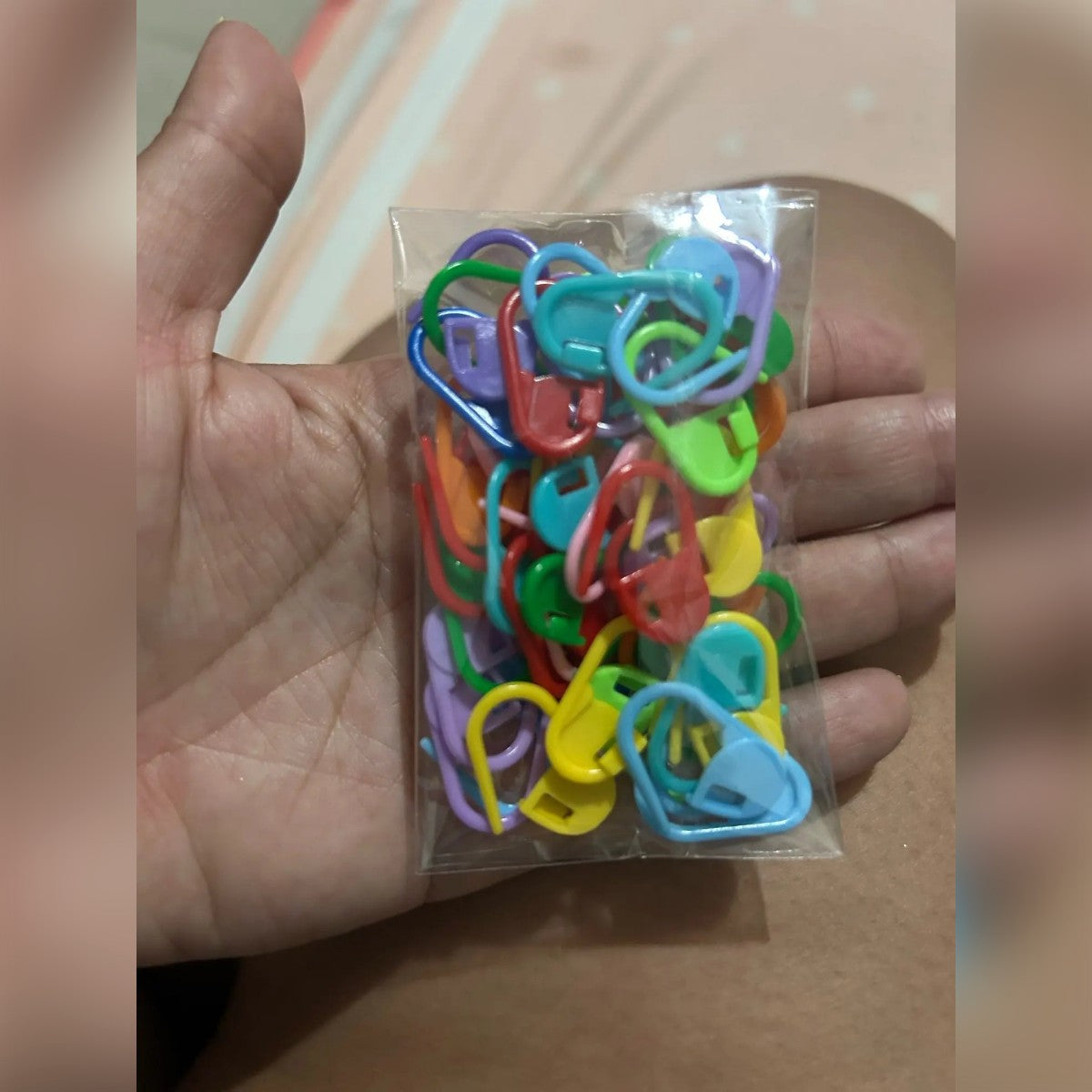 Foto cliente: i 50 marcapunti in colori misti nella bustina trasparente sul palmo di una mano