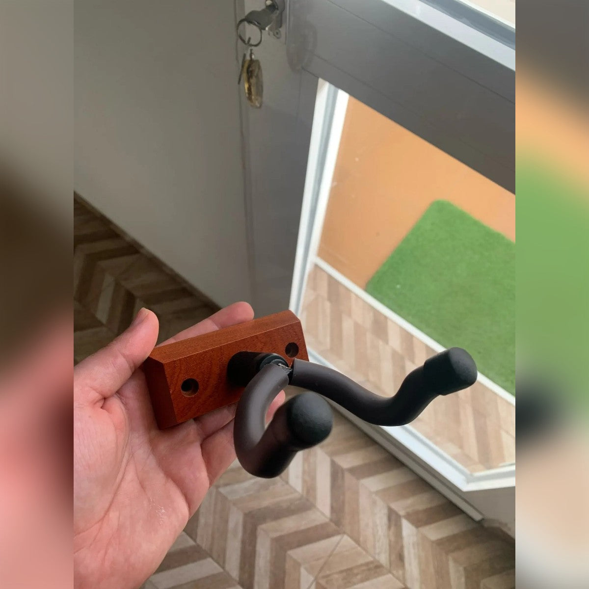 Foto di un acquirente: il porta chitarra in mano prima del montaggio, base in legno bruno-rossiccio