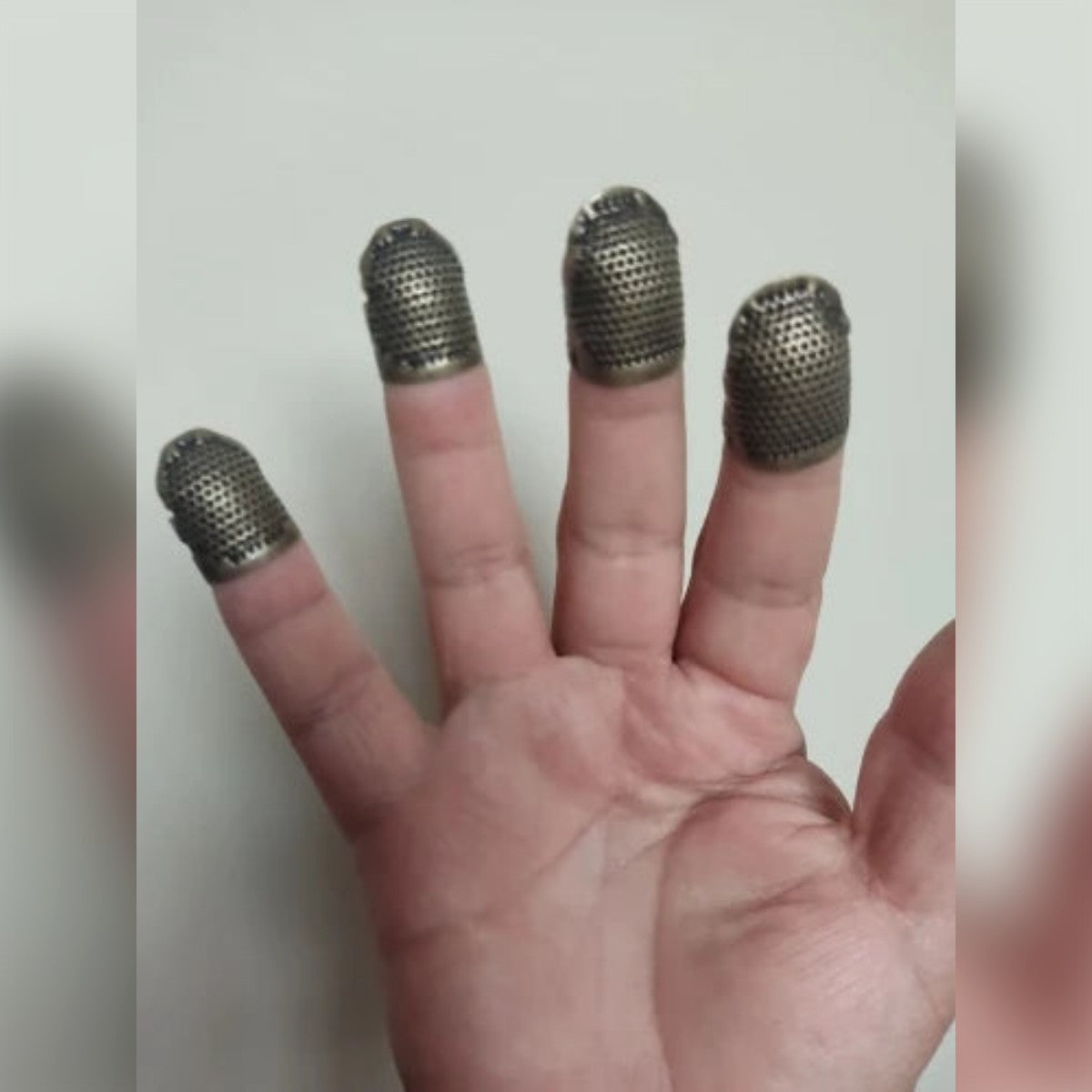 Foto di un acquirente: quattro ditali su quattro dita