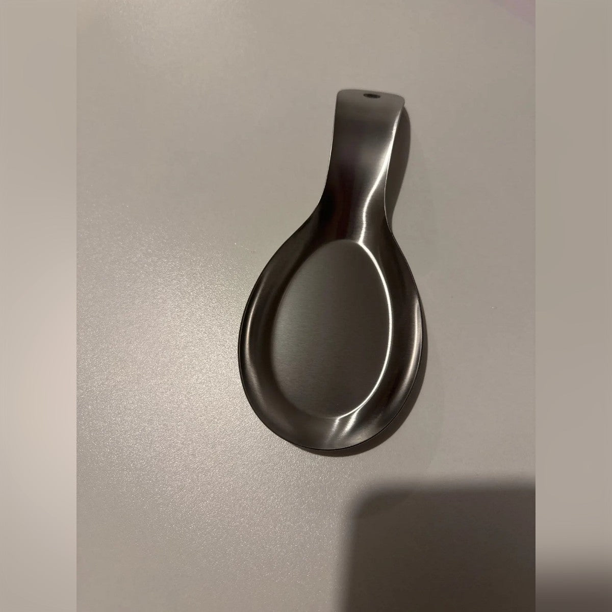 Foto di un acquirente: il poggiamestolo su un tavolo grigio, con il foro in vista