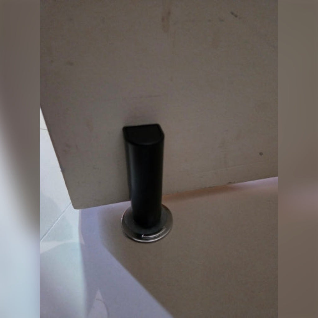 Foto di un acquirente: il fermaporta nero montato in basso su una porta bianca, sopra la piastra