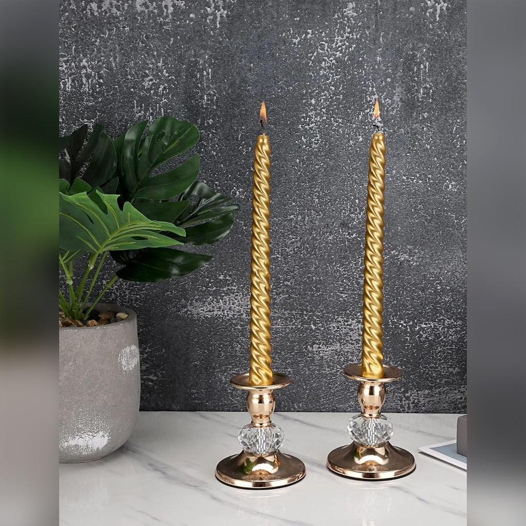 Candele dorate accese nei due candelieri davanti a una parete scura