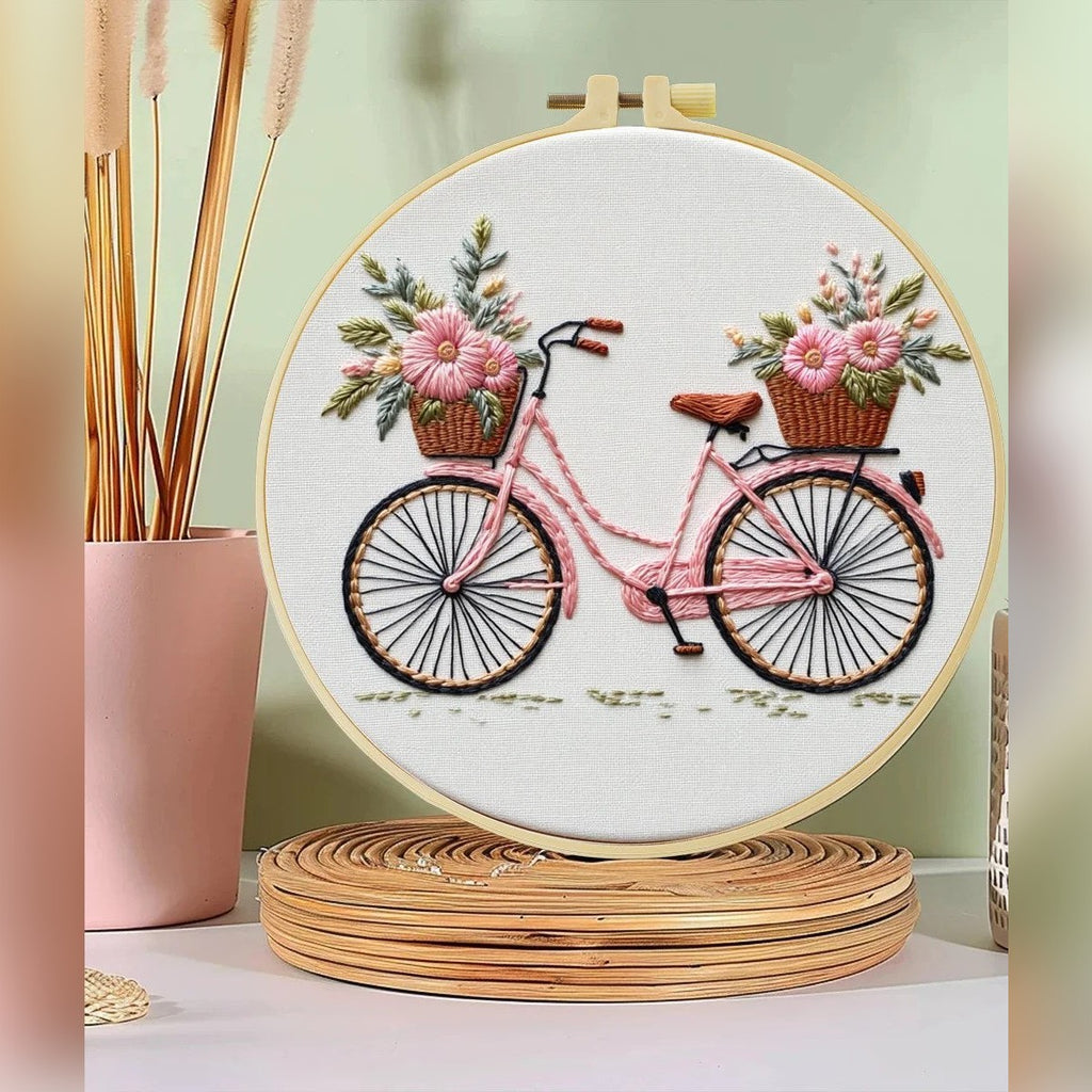 Kit ricamo con bicicletta e cesti di fiori – il ricamo finito nel telaio su una mensola, foto del fornitore