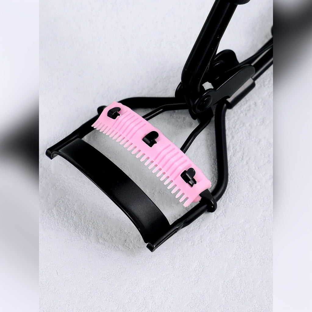Primo piano dell'archetto nero e del cuscinetto rosa con il pettine