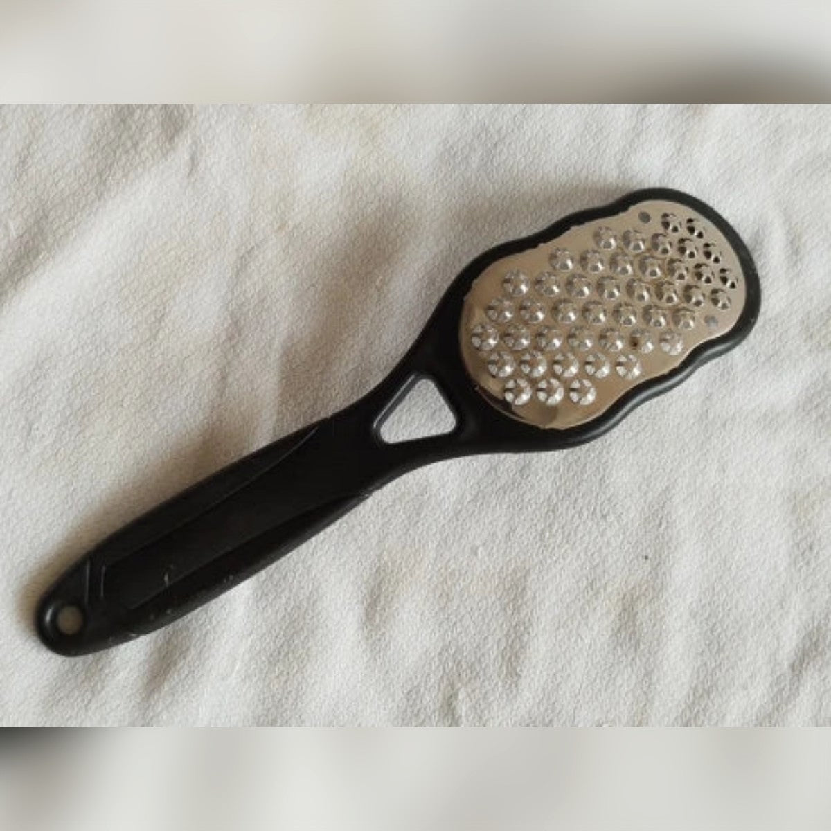 Foto di un cliente: la raspa nera appoggiata su un tessuto bianco