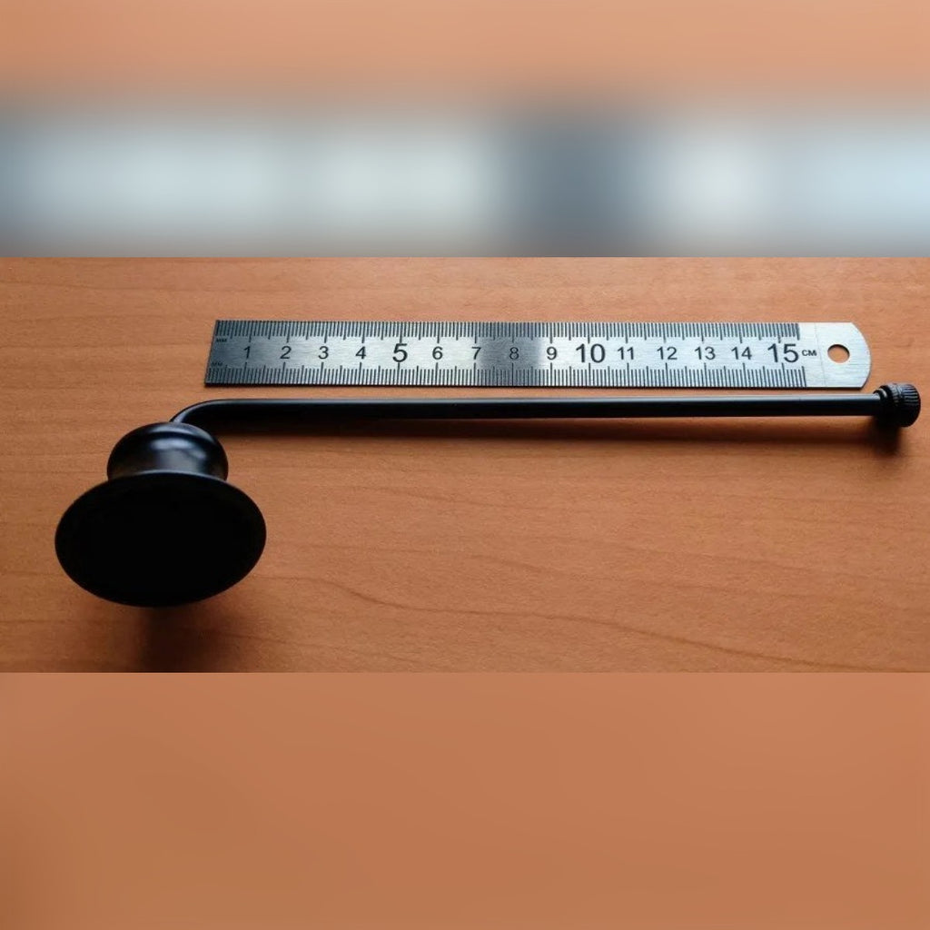 Foto di un cliente: lo spegnicandela nero accanto a un righello da 15 cm