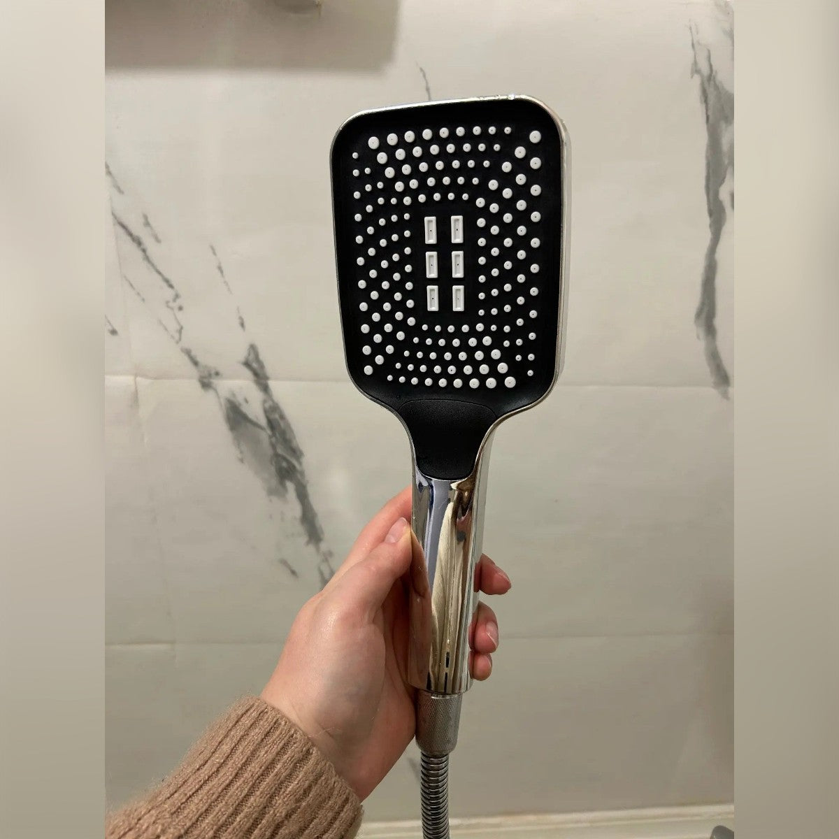 Foto di un cliente: il doccino in mano davanti a una parete in marmo