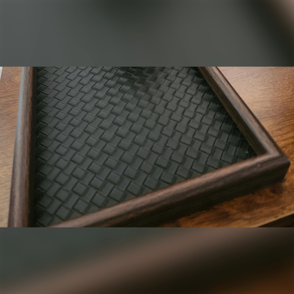 Foto di un cliente: svuotatasche nero con cornice effetto legno su un comodino