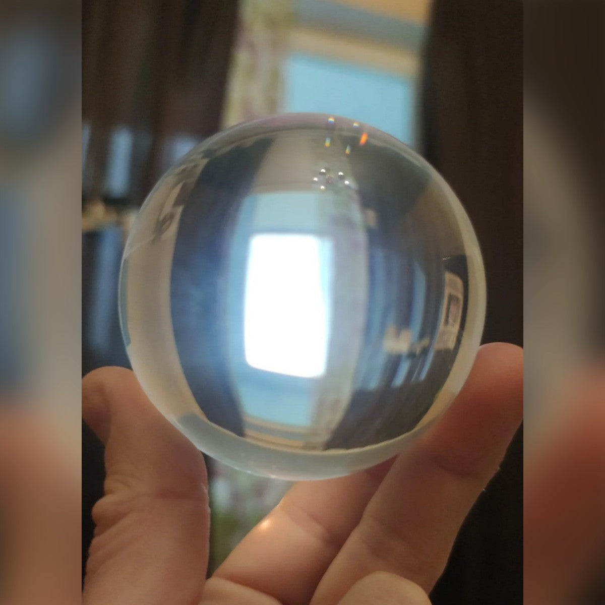 Foto di un cliente: sfera di vetro trasparente tenuta in mano, la finestra appare capovolta (nella foto la sfera da 100 mm)