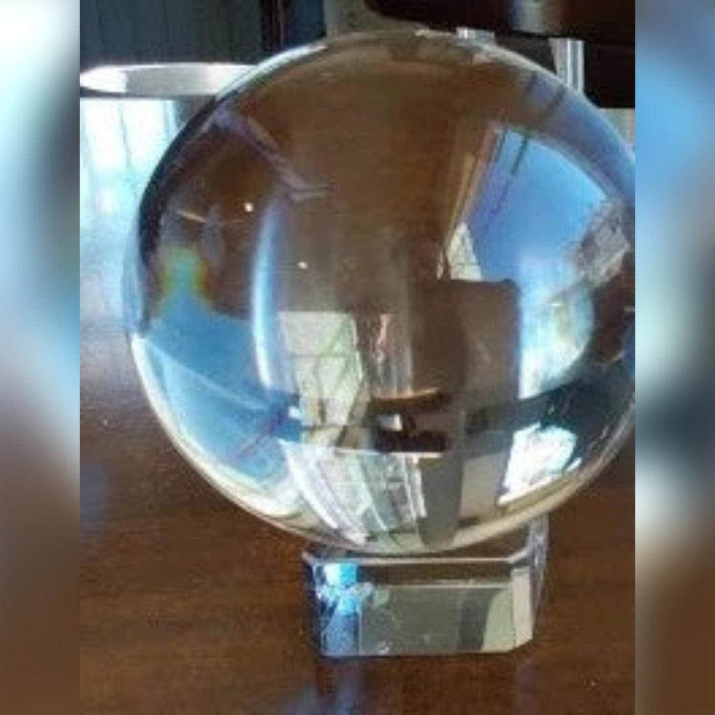 Foto di un cliente: sfera di vetro trasparente sul suo supporto su un tavolo (nella foto la sfera da 80 mm)