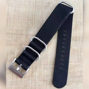 Foto di un cliente: cinturino NATO nero con fibbia color argento e tre passanti su un tavolo di legno