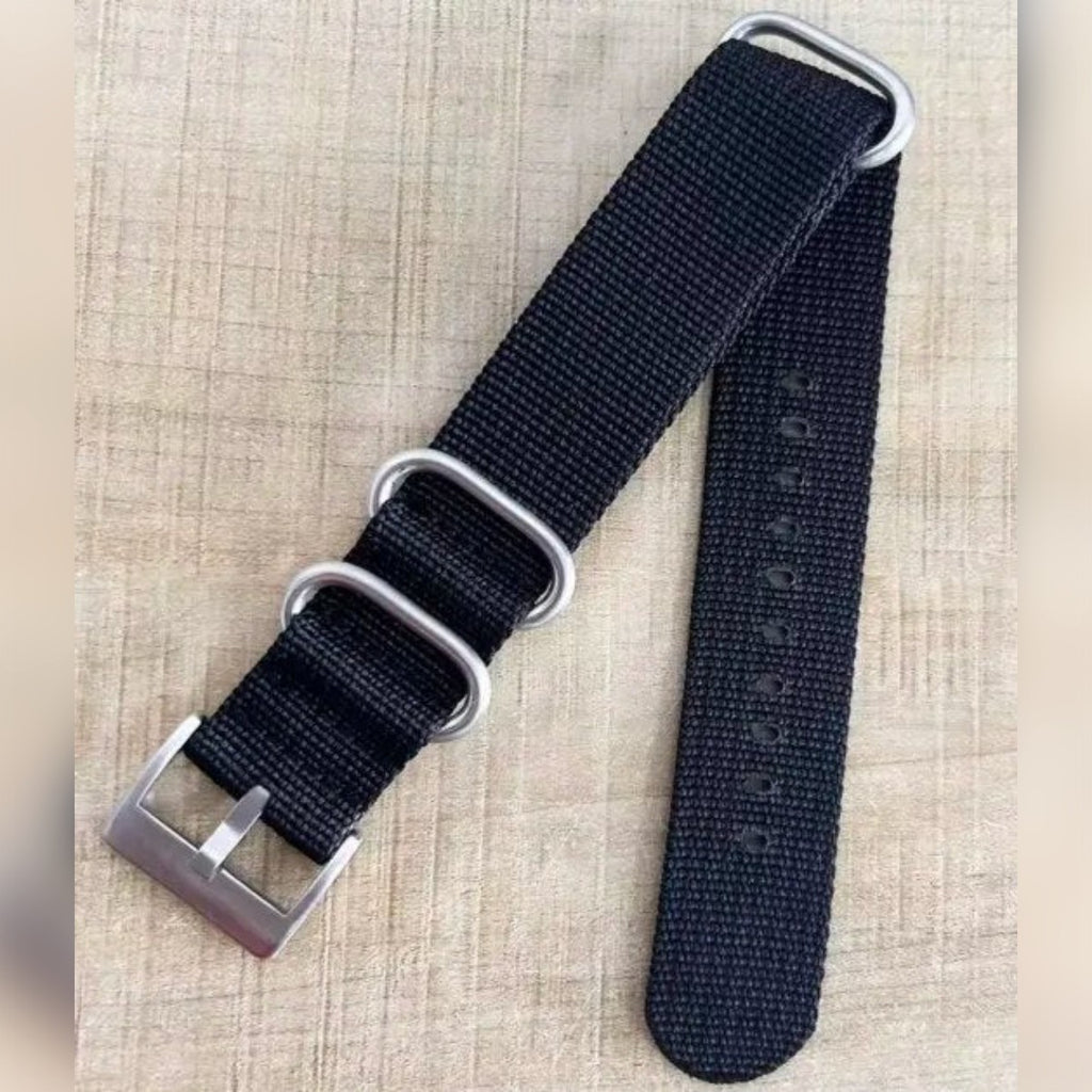 Foto di un cliente: cinturino NATO nero con fibbia color argento e tre passanti su un tavolo di legno
