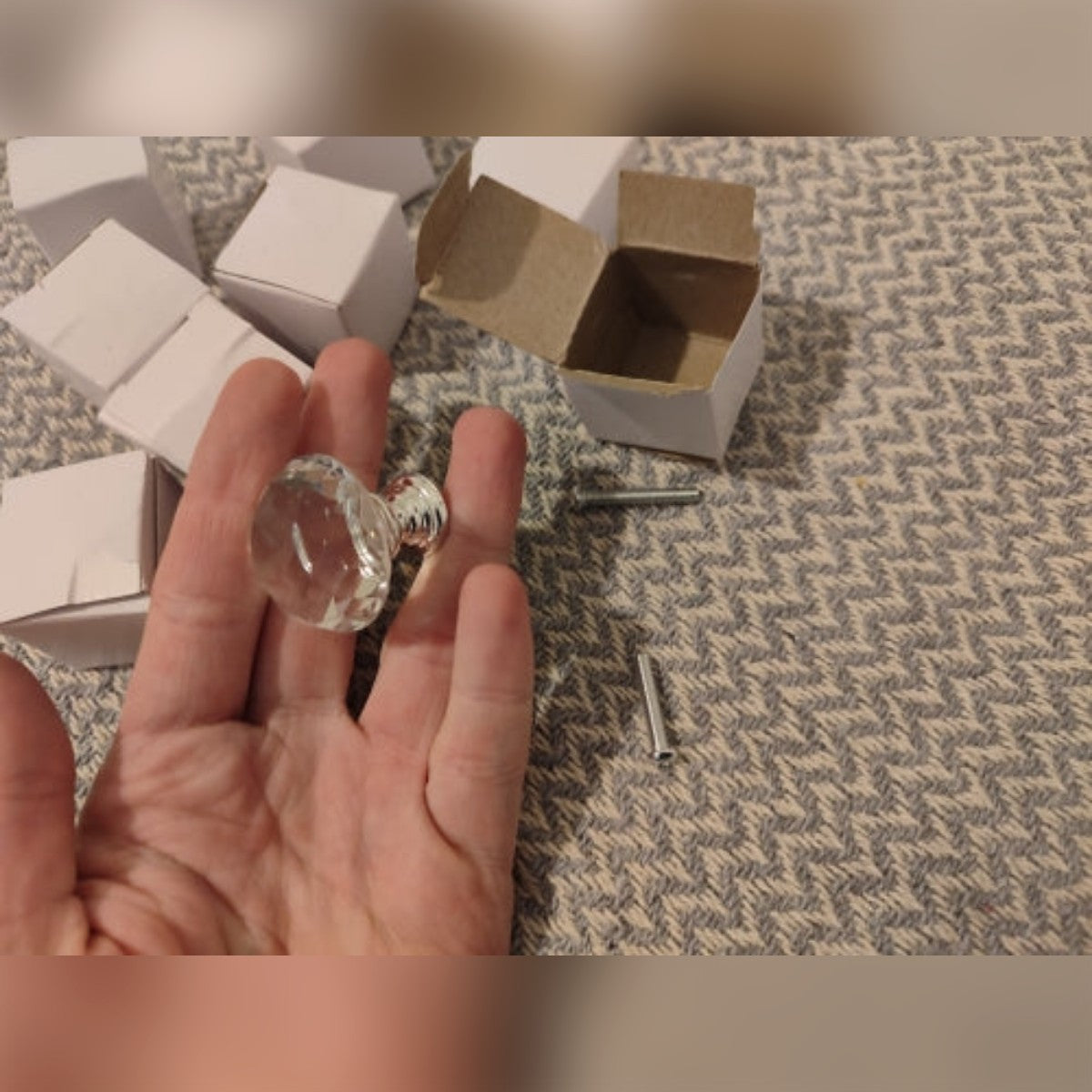 Foto di un cliente: un pomello in vetro in mano e due viti