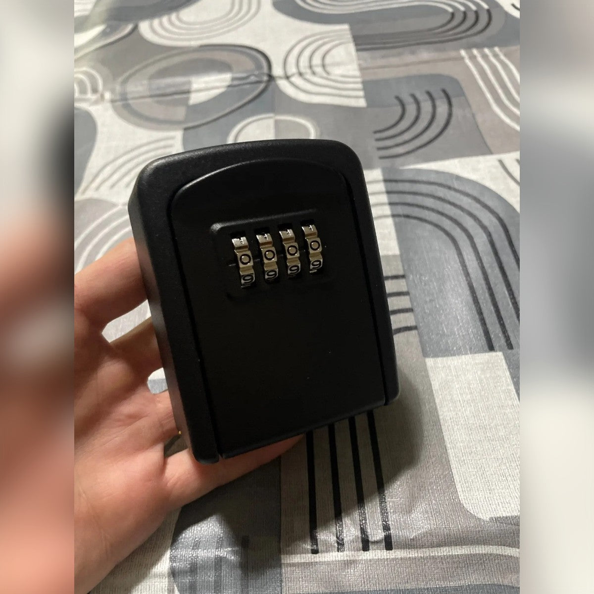 Foto di un cliente: la key box nera tenuta in mano, vista di fronte con le quattro rotelle